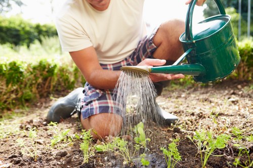 Team working on sustainable garden maintenance in Wood Green with green waste bins
