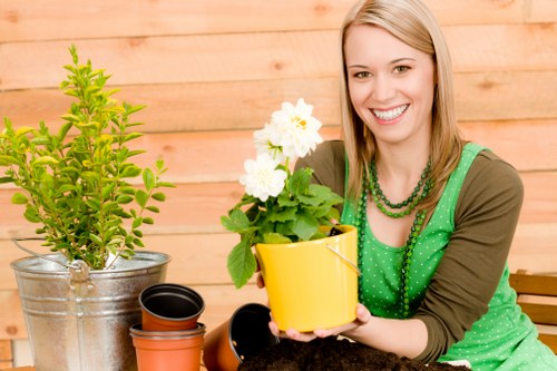 Staff performing garden maintenance near a residential property